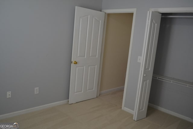 unfurnished bedroom with baseboards and light carpet