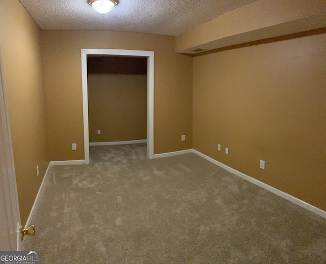 unfurnished bedroom featuring carpet, baseboards, a closet, and a textured ceiling