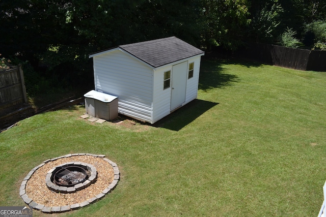 view of shed featuring an outdoor fire pit and fence