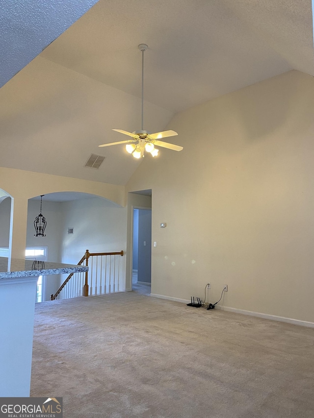 empty room featuring visible vents, high vaulted ceiling, baseboards, and carpet floors