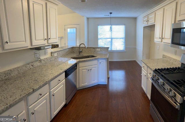 kitchen featuring a sink, stainless steel appliances, a peninsula, and white cabinetry