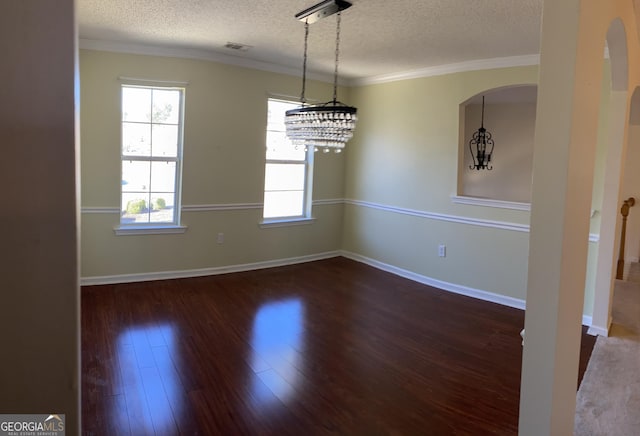 unfurnished dining area featuring baseboards, a textured ceiling, wood finished floors, and ornamental molding