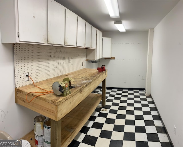 interior space featuring tile patterned floors and a workshop area