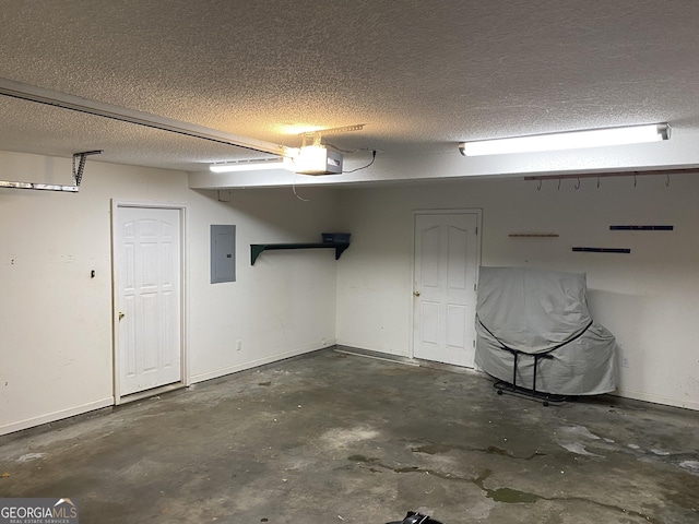 garage with electric panel, a garage door opener, and baseboards