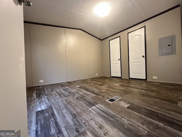 unfurnished bedroom with electric panel, visible vents, lofted ceiling, and wood finished floors