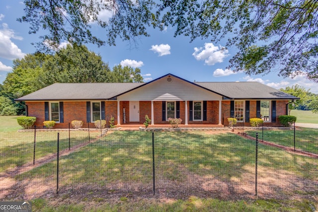 ranch-style home featuring brick siding, a porch, a front yard, and fence