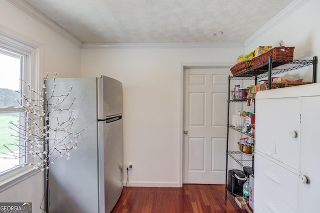 kitchen with a healthy amount of sunlight, dark wood-style flooring, freestanding refrigerator, and ornamental molding