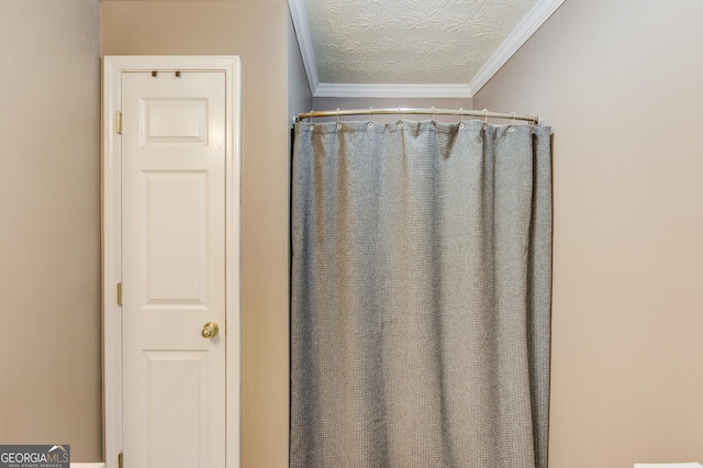 bathroom with curtained shower, a textured ceiling, and crown molding