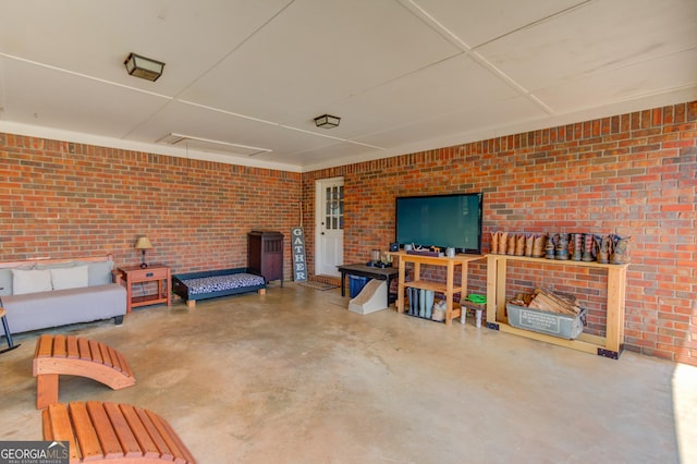 living area featuring brick wall and concrete flooring