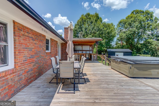 wooden deck featuring outdoor dining space and a hot tub