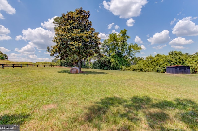 view of yard with a rural view and fence