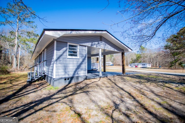 view of front of property with crawl space, an attached carport, covered porch, and driveway