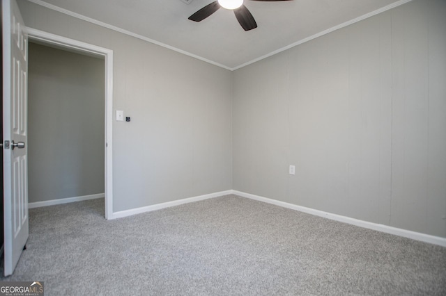 empty room with crown molding, baseboards, carpet floors, and ceiling fan