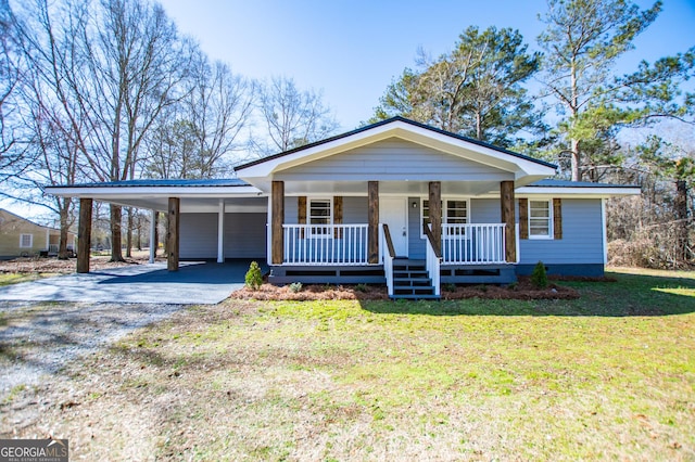 view of front facade with an attached carport, driveway, covered porch, a front lawn, and metal roof