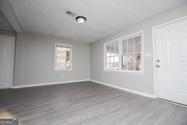 interior space with visible vents, baseboards, and wood finished floors