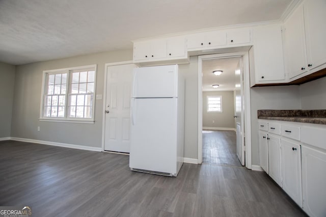 kitchen with dark countertops, white cabinets, freestanding refrigerator, and dark wood-style flooring