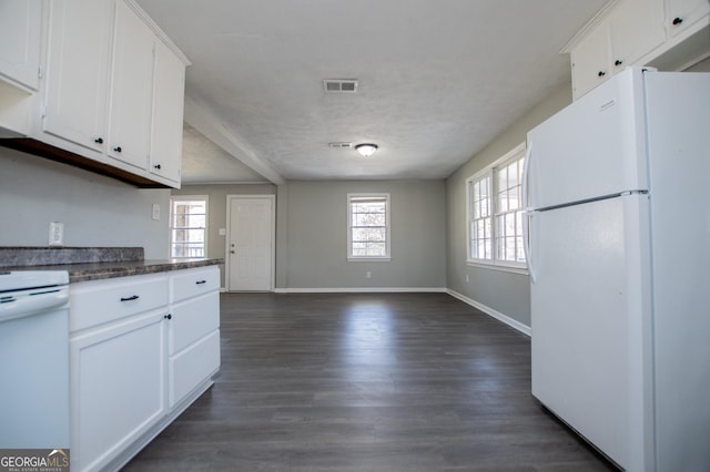 kitchen featuring visible vents, electric range, dark wood-style flooring, freestanding refrigerator, and white cabinetry