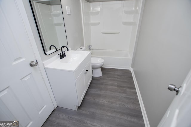 bathroom with toilet, vanity, baseboards, and wood finished floors