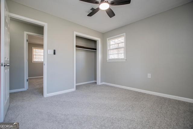 unfurnished bedroom featuring visible vents, baseboards, carpet flooring, a closet, and a ceiling fan