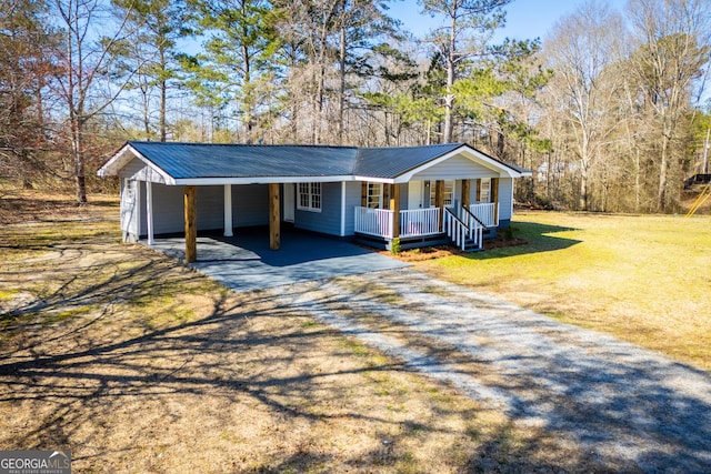 single story home with dirt driveway, a front yard, covered porch, metal roof, and a carport