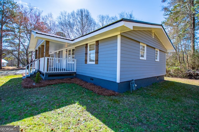 view of property exterior featuring crawl space, covered porch, and a yard