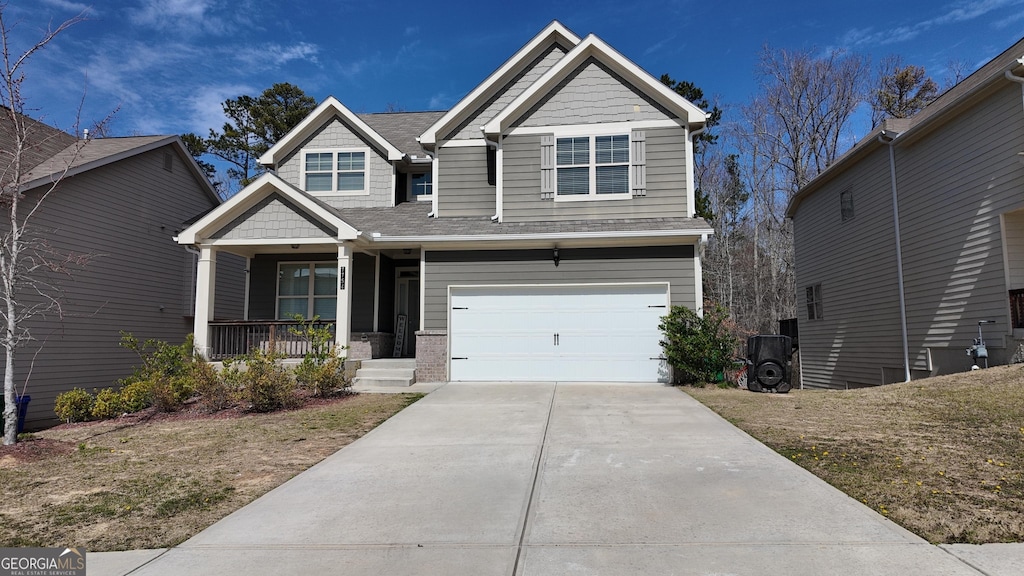 craftsman-style house featuring a porch, a garage, and driveway