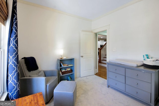 sitting room featuring light carpet, ornamental molding, and stairs