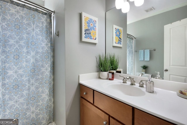 bathroom with vanity, a shower with shower curtain, visible vents, and ornamental molding