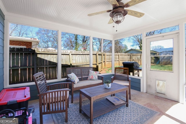 sunroom / solarium featuring plenty of natural light and ceiling fan