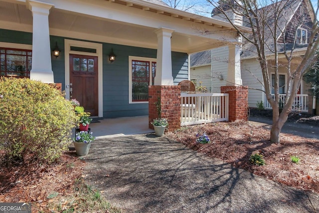 property entrance with brick siding and covered porch