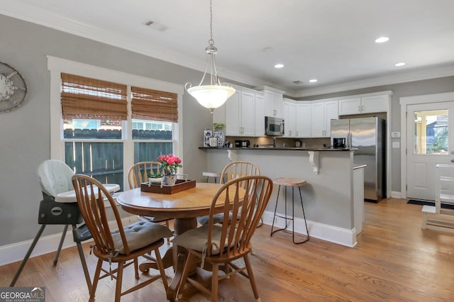 dining area with recessed lighting, light wood-type flooring, baseboards, and crown molding