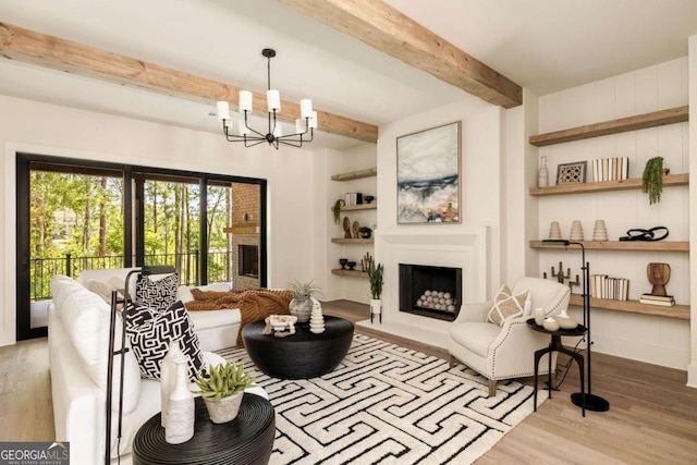 living room featuring wood finished floors, built in features, a fireplace with raised hearth, and beam ceiling