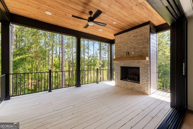 exterior space with a ceiling fan, a brick fireplace, and wood ceiling