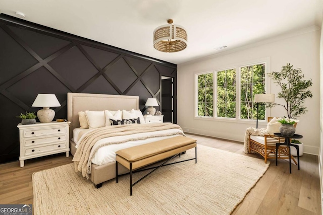 bedroom featuring visible vents, baseboards, and wood finished floors