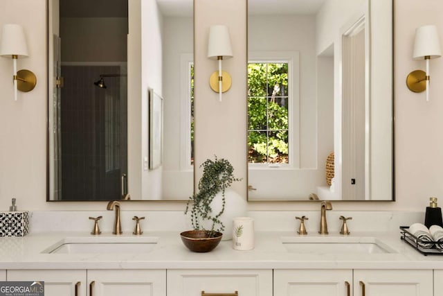 full bath with double vanity, a stall shower, and a sink