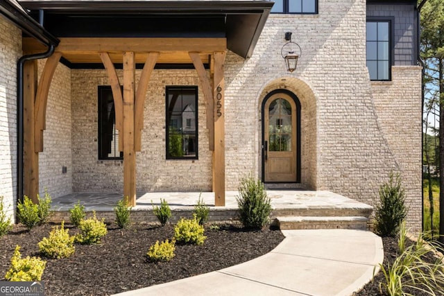 doorway to property with brick siding