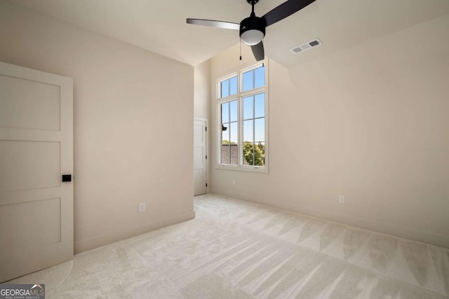 empty room featuring a high ceiling, carpet, visible vents, and ceiling fan