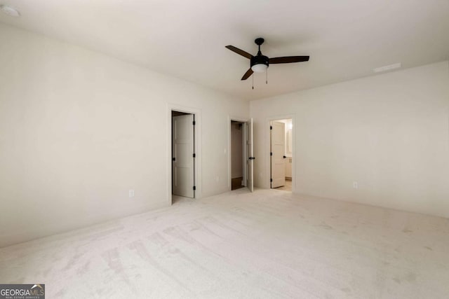 spare room featuring light colored carpet and ceiling fan