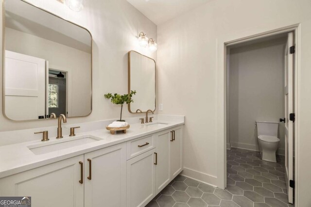 6055 Tattnall Overlook, Acworth, GA 30101 - full bathroom with double vanity, toilet, tile patterned flooring, and baseboards