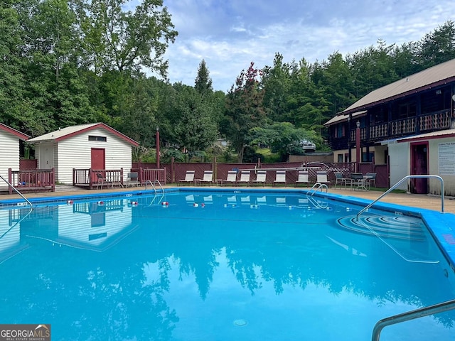 view of pool featuring an outdoor structure and fence