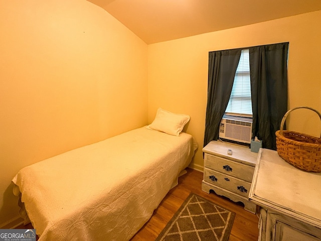 bedroom with lofted ceiling and wood finished floors