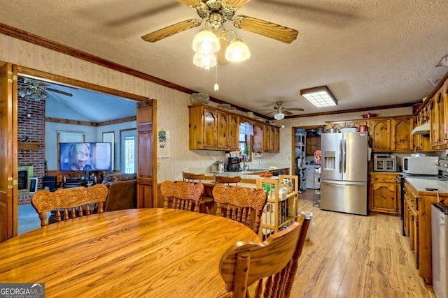 dining space featuring a textured ceiling, a ceiling fan, light wood-style floors, and ornamental molding