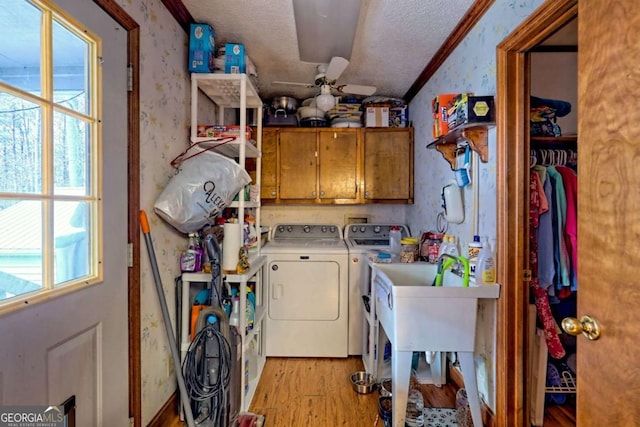 clothes washing area with wallpapered walls, a textured ceiling, cabinet space, light wood finished floors, and ceiling fan