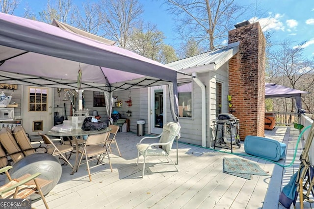 deck with a gazebo, outdoor dining area, and a grill