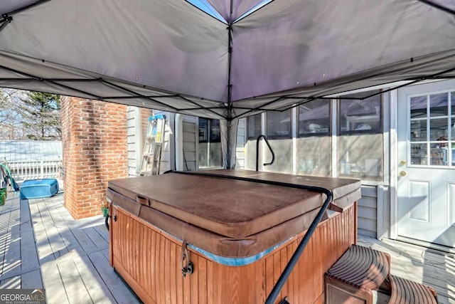 wooden terrace featuring a hot tub