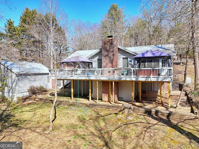 back of house with stairway, an outbuilding, a deck, and a chimney