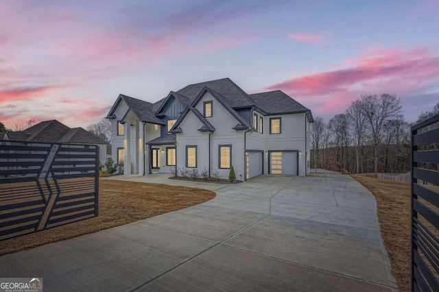 view of front of house featuring driveway, fence, board and batten siding, roof with shingles, and a garage