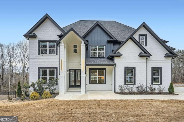 view of front of home with brick siding, french doors, and board and batten siding