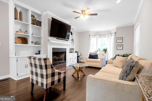 living room featuring visible vents, a fireplace with flush hearth, dark wood-style flooring, ceiling fan, and crown molding