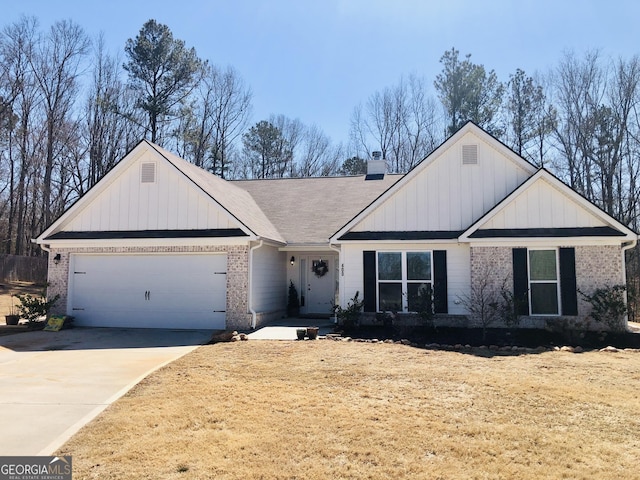 view of front of property with brick siding, an attached garage, board and batten siding, a chimney, and driveway